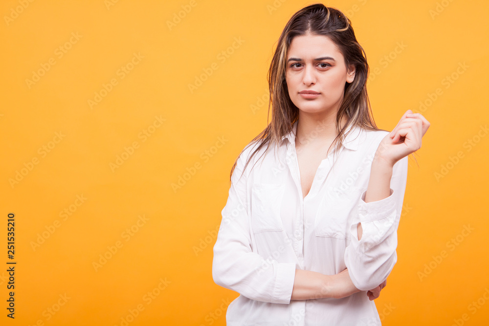Skeptical beautiful young girl over yellow background Skeptical beautiful young girl over yellow background