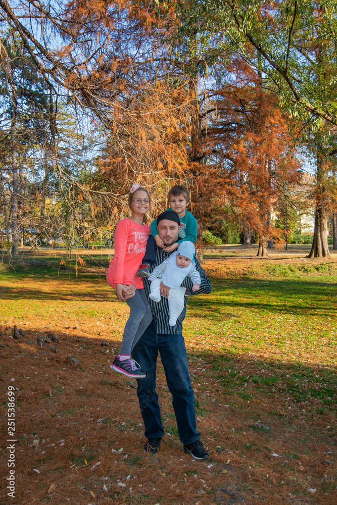 Dad with three children in the arms in the park Dad with three children in the arms in the park