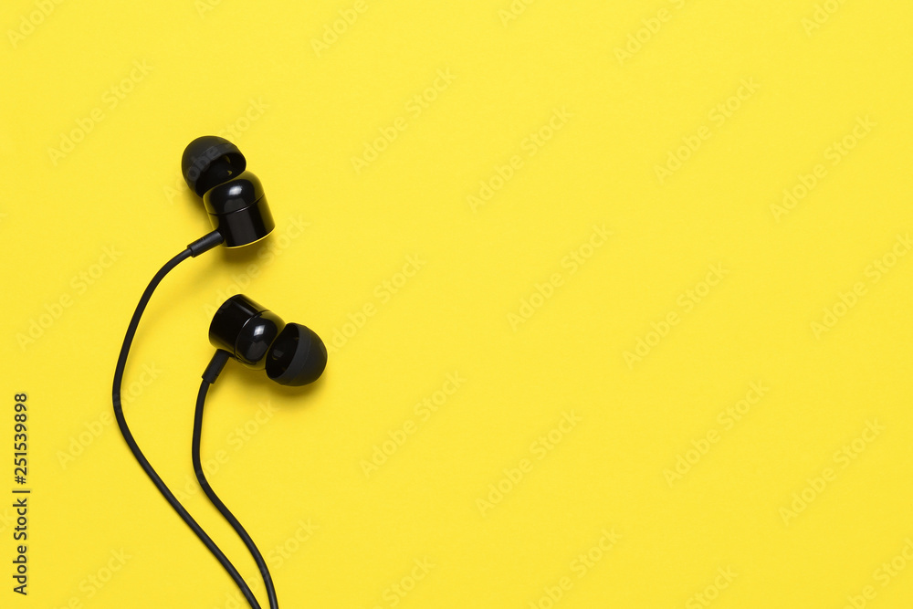 Earbuds on yellow background with text space Earbuds on yellow background with text space