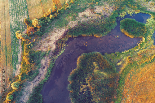 The winding brook flows through the field, aerial view