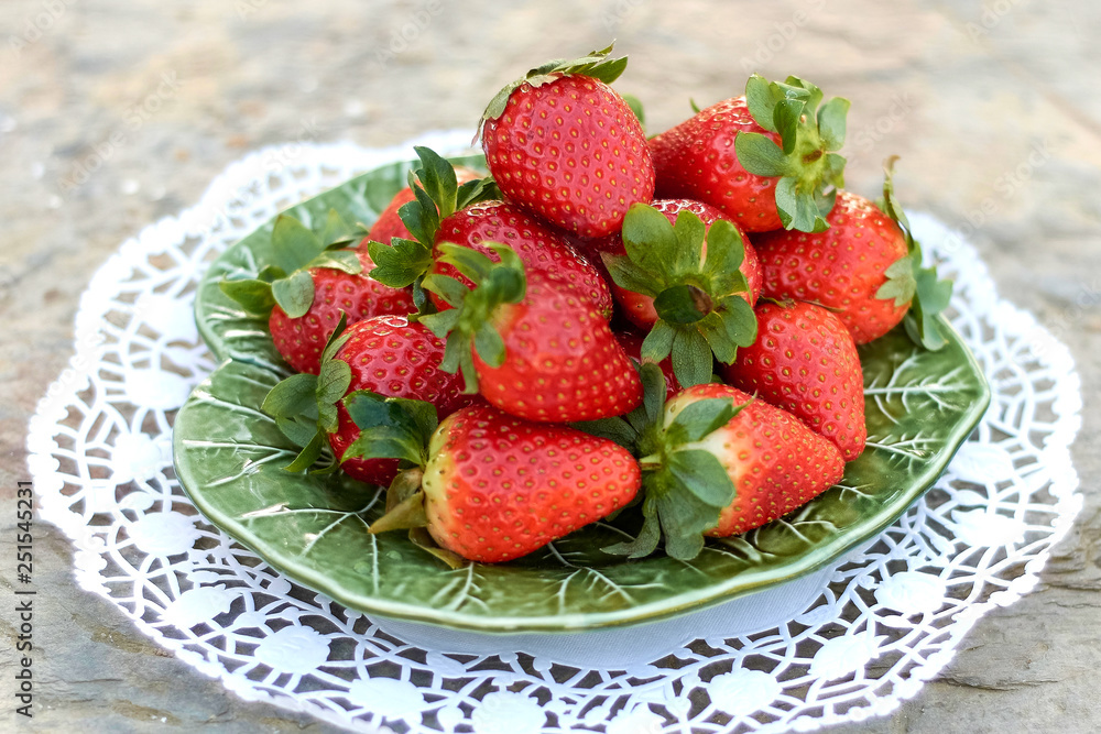 strawberries on green plate and light background. strawberries on green plate and light background.