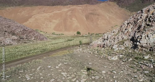 Aerial drone scene of sand dune in rocky mounrainous landscape. Contrast with green valley and dry desertic slopes. Abra Pampa, Jujuy, Argetina. Huancar dunes photo