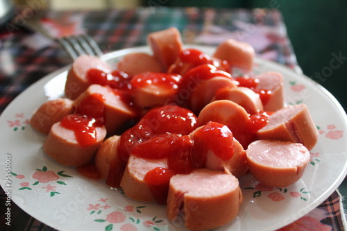 sausages on a plate with ketchup
