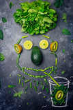 Green detox healthy smoothie from green fruit, avocado, salad, kale, lime, kiwi, mint. Food face, fun food for kids idea. Alkaline diet concept. Vegan healthy alkaline food. Flat lay.