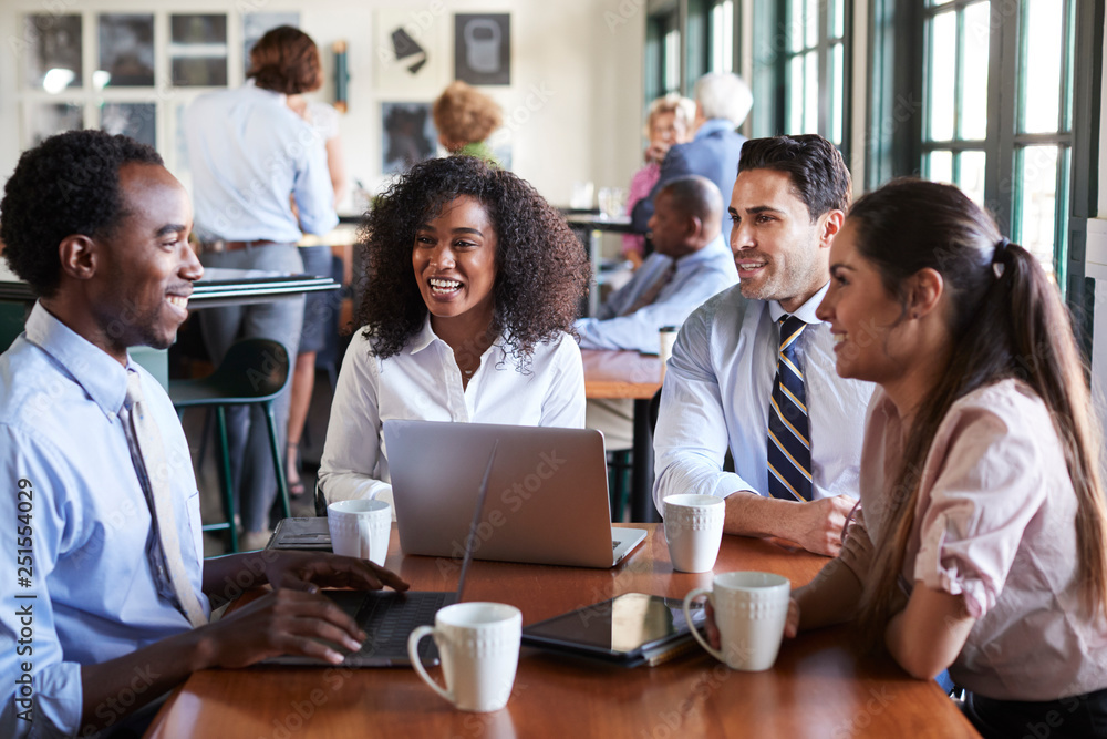 Business Team Having Informal Meeting Around Table In Coffee Shop Business Team Having Informal Meeting Around Table In Coffee Shop