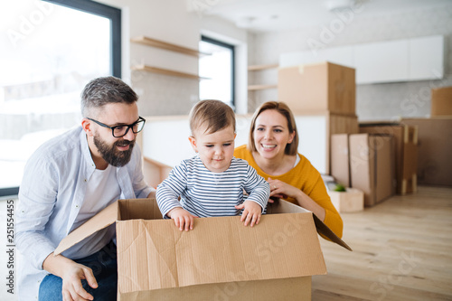 Bilde på lerret A portrait of young family with a toddler girl moving in new home