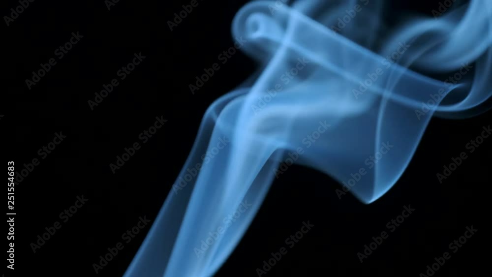 Thin trickle of blue smoke slowly rising graceful twists up on black background. Smoke billow rising swirl to top on black background. Closeup Thin trickle of blue smoke slowly rising graceful twists up on black background. Smoke billow rising swirl to top on black background. Closeup