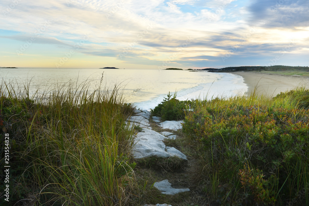 The conquest of the Atlantic Ocean. View from the wild coast to the beach and islands in the distance at sunset. Maine. USA. Reid National Park. The conquest of the Atlantic Ocean. View from the wild coast to the beach and islands in the distance at sunset. Maine. USA. Reid National Park.