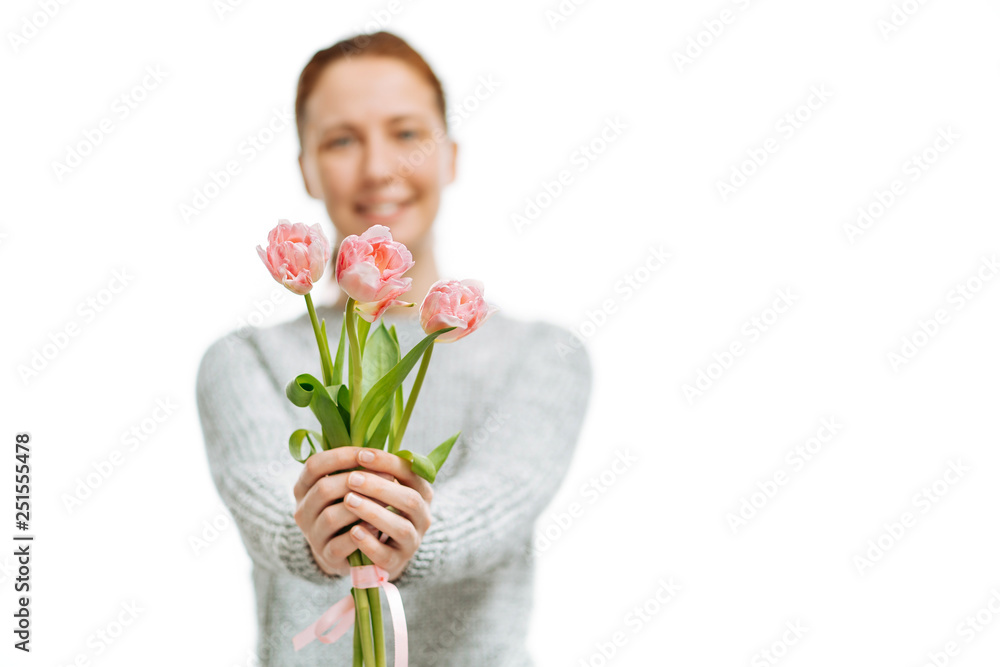 Young beautiful woman gives pink tulips on white background. Young beautiful woman gives pink tulips on white background.