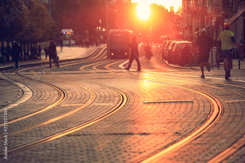 Fototapeta Naklejka Na Ścianę i Meble -  Selective ofcus on pavement, city street scene, people walking on street with tramway during the sunset in Bordeaux, France
