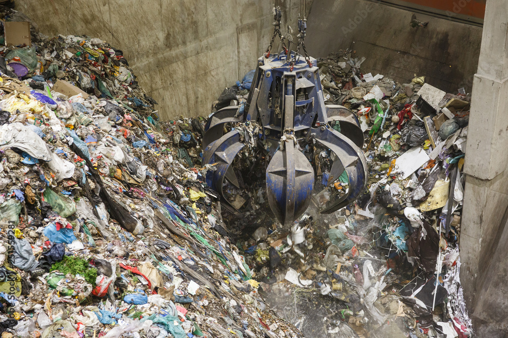 Mechanical claw hand grabbing pile of mixed waste Stock Photo | Adobe Stock