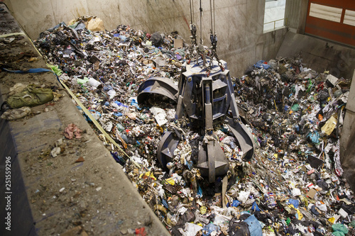 Mechanical claw hand grabbing pile of mixed waste