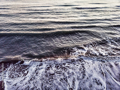 Ocean wave breaks into the coast with backwash