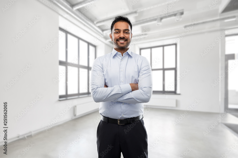 business, realty and people concept - smiling indian businessman or realtor over empty office room background business, realty and people concept - smiling indian businessman or realtor over empty office room background