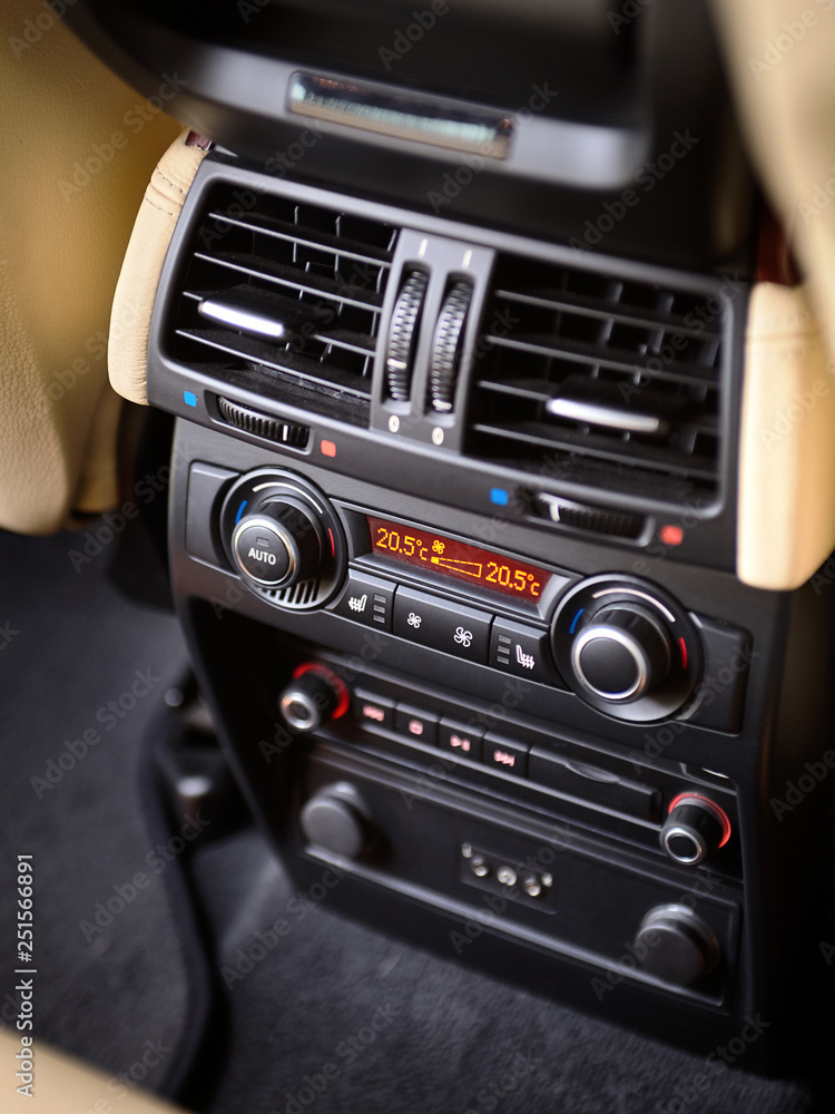 Modern car climate control panel for passengers in rear row with shallow depth of field. Four zone climate control