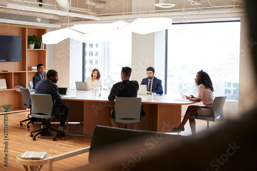 Group Of Business Professionals Meeting Around Table In Modern Office