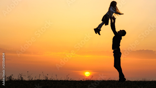 Silhouettes of happy child rushes into hands of father.