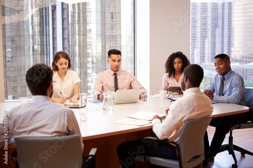 Group Of Business Professionals Meeting Around Table In Modern Office