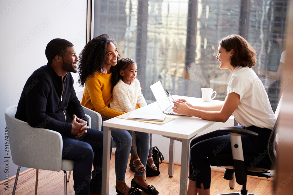 Family Having Consultation With Female Pediatrician In Hospital Office Family Having Consultation With Female Pediatrician In Hospital Office