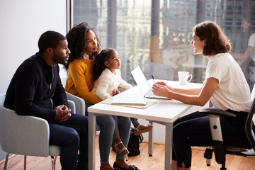 Family Having Consultation With Female Pediatrician In Hospital Office