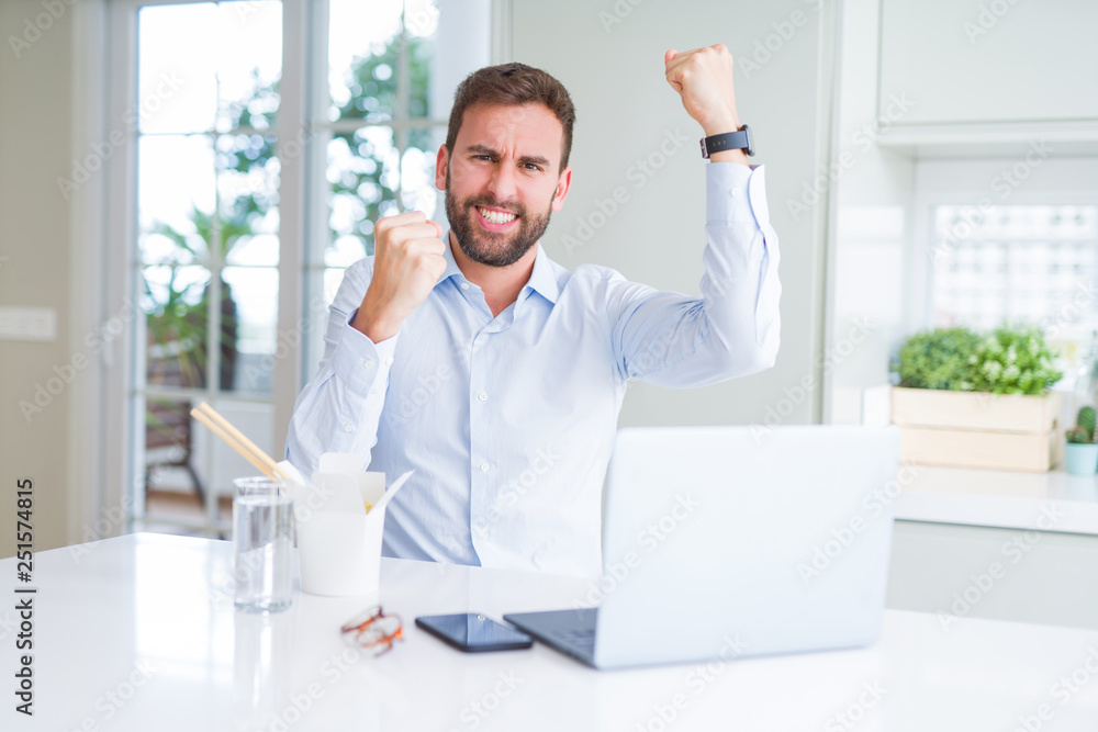 Business man eating take away asian noodles food while working using computer laptop and smiling