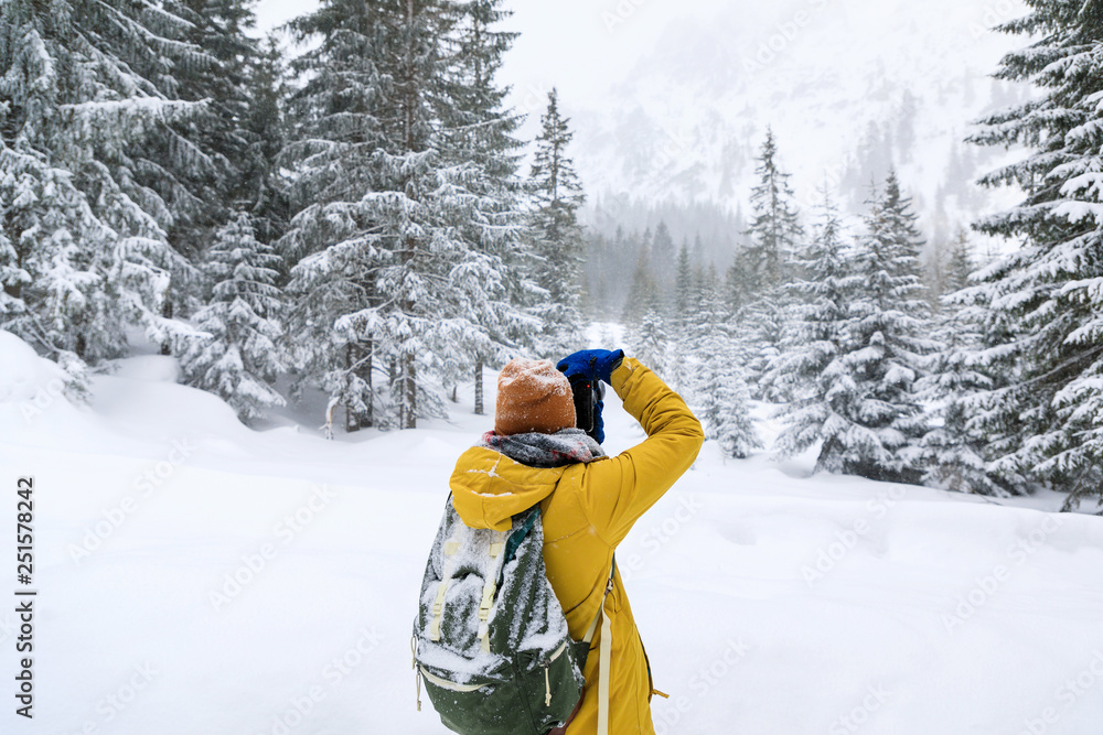 The photographer in winter forest in mountains