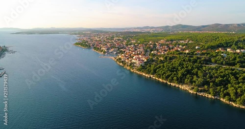 Village on croatian coast, C4k aerial, drone shot, towards the Brodarica town, on the mediterranean shore and the adriatic sea, near Sibenik, on a sunny, summer evening, in Croatia photo