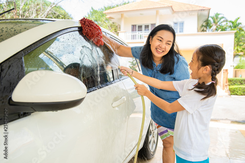 Happy asian little girl enjoy washing car
