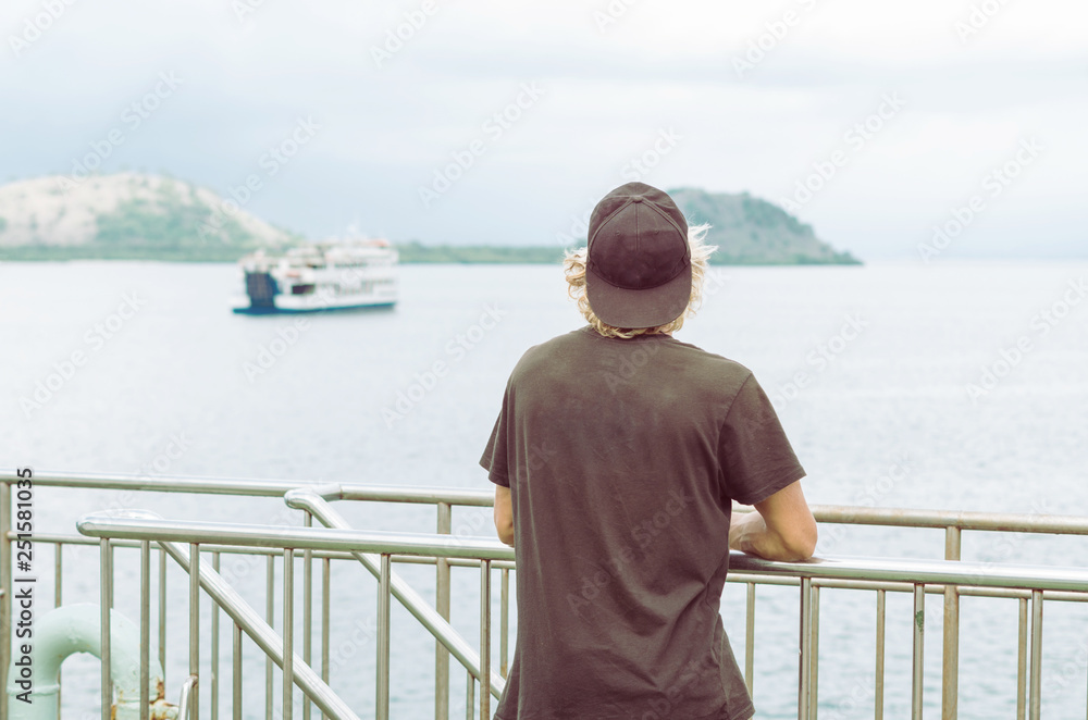 Anonymous surfer traveling around the world by a ferry boat. Bali-Lombok-Sumbawa ferry trip. Summer holidays background.