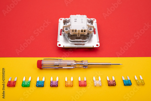 Set of electrical tool and white socket on colorful background photo