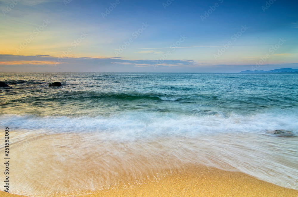 Travel And vacation concept background, beautiful tropical beach sunrise sea view. soft wave hitting sandy beach