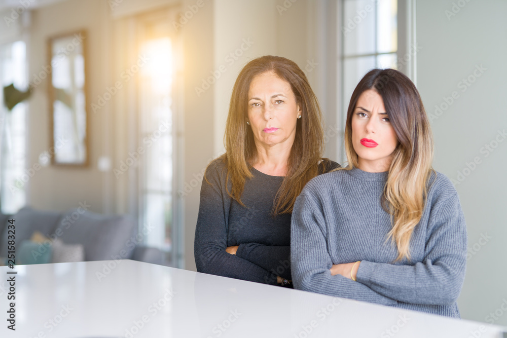 Beautiful family of mother and daughter together at home skeptic and nervous, disapproving expression on face with crossed arms. Negative person. Beautiful family of mother and daughter together at home skeptic and nervous, disapproving expression on face with crossed arms. Negative person.