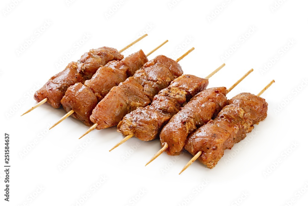 Raw chicken skewers on a white background