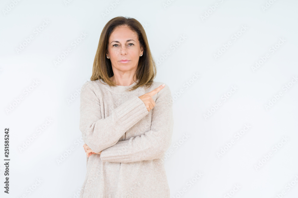 Beautiful middle age woman over isolated background Pointing with hand finger to the side showing advertisement, serious and calm face Beautiful middle age woman over isolated background Pointing with hand finger to the side showing advertisement, serious and calm face