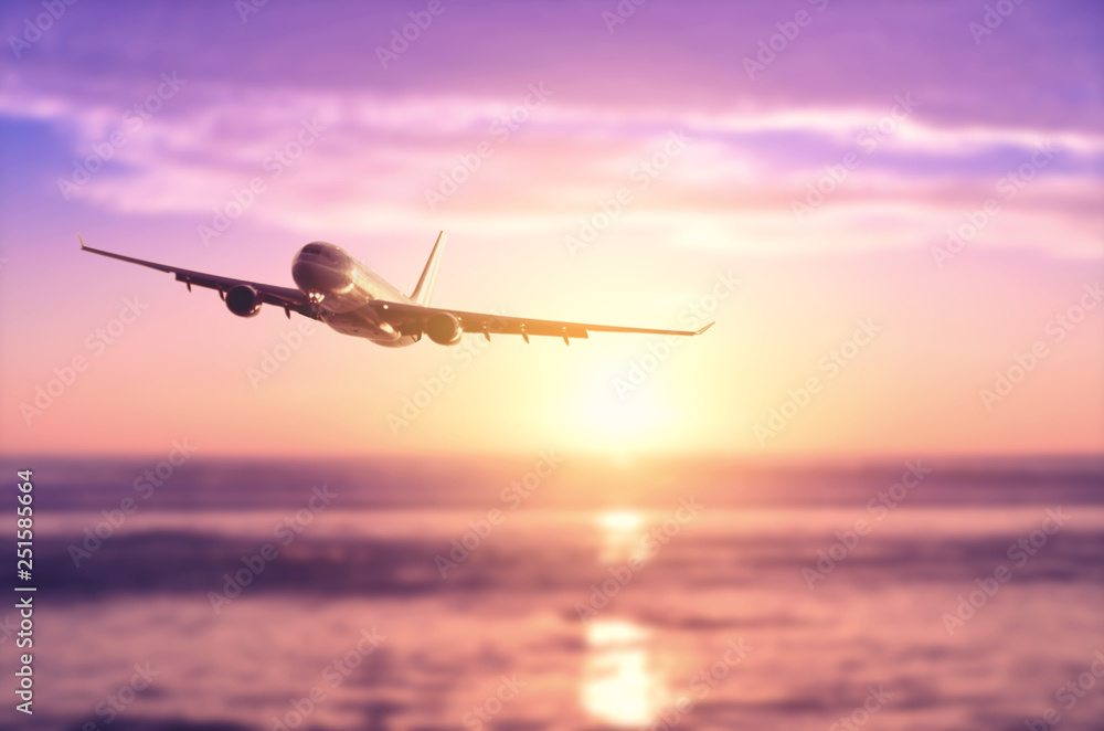 Fototapeta Samolot lecący nad rozmycie tropikalnej plaży z gładką falą i zachód słońca niebo streszczenie tło.