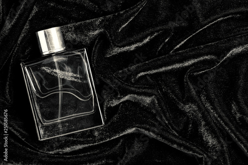 Male perfume bottle with copy space on black fabric background