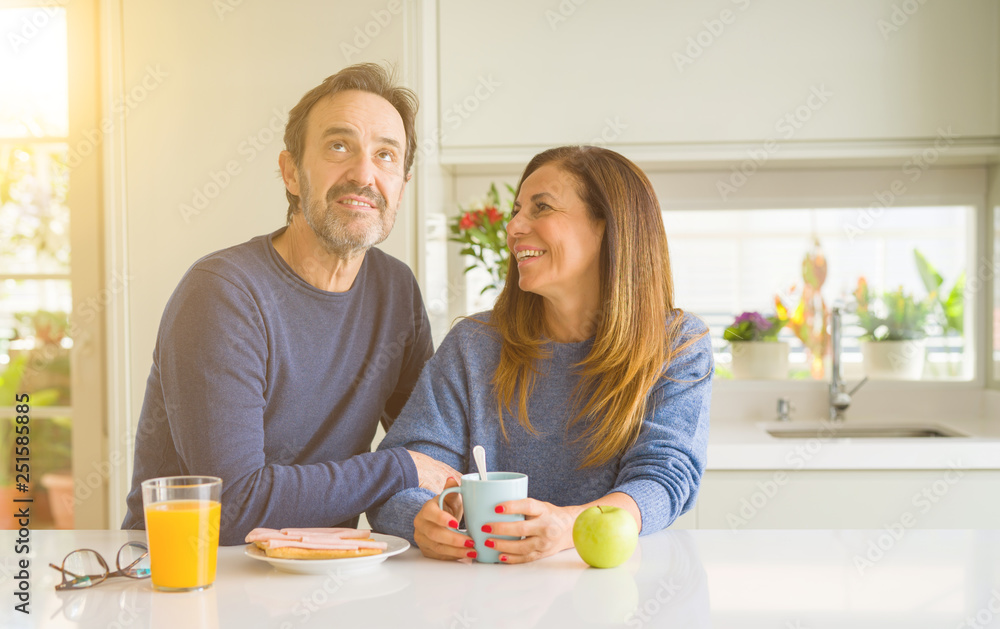 Beautiful romantic middle age couple having healthy breaskfast in the morning at home Beautiful romantic middle age couple having healthy breaskfast in the morning at home