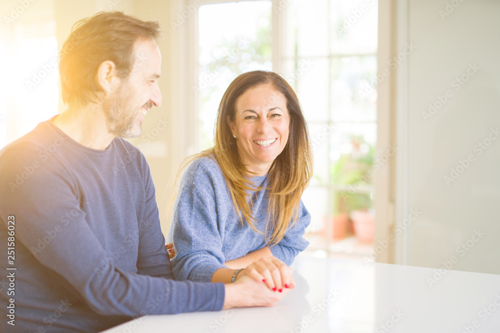 Romantic middle age couple sitting together at home Romantic middle age couple sitting together at home