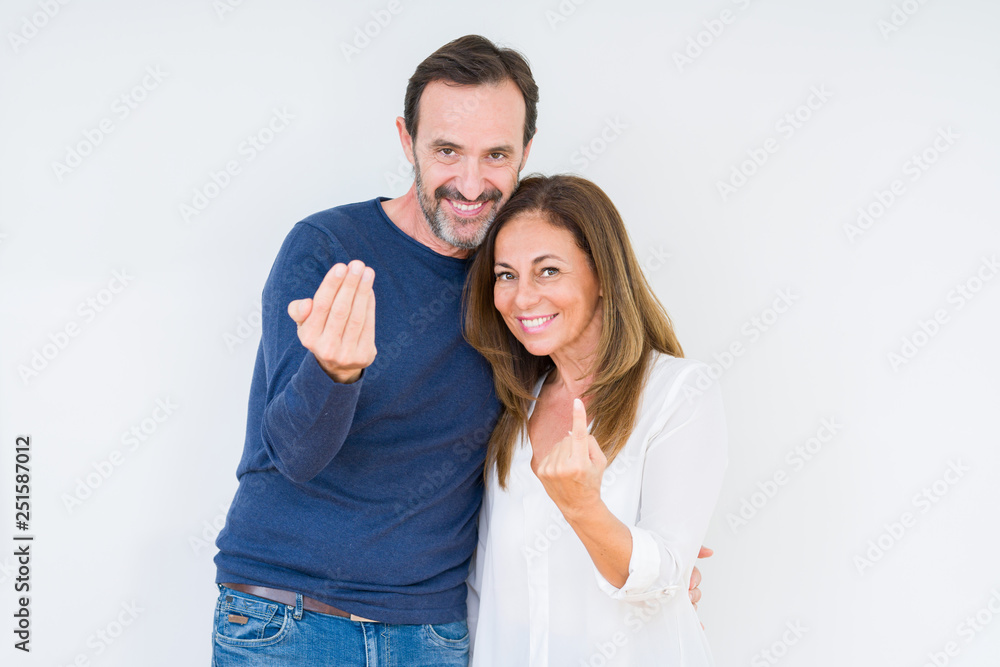 Beautiful middle age couple in love over isolated background Beckoning come here gesture with hand inviting happy and smiling Beautiful middle age couple in love over isolated background Beckoning come here gesture with hand inviting happy and smiling