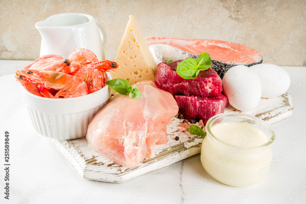 Animal protein sources - raw beef meat steak, chicken breast fillet, salmon fish, eggs, dairy milk, shrimps, cheese, copy space Animal protein sources - raw beef meat steak, chicken breast fillet, salmon fish, eggs, dairy milk, shrimps, cheese, copy space