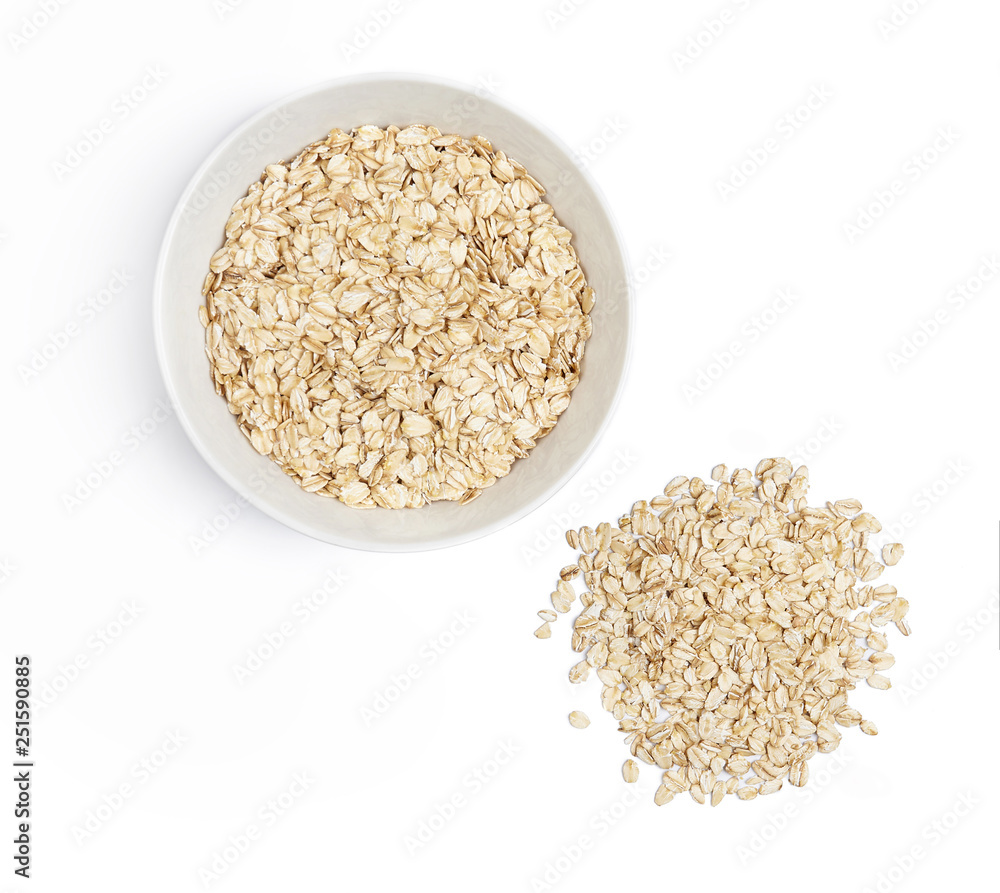 A bowl with oat-flakes and pile of oats cut out. Top view. A bowl with oat-flakes and pile of oats cut out. Top view.