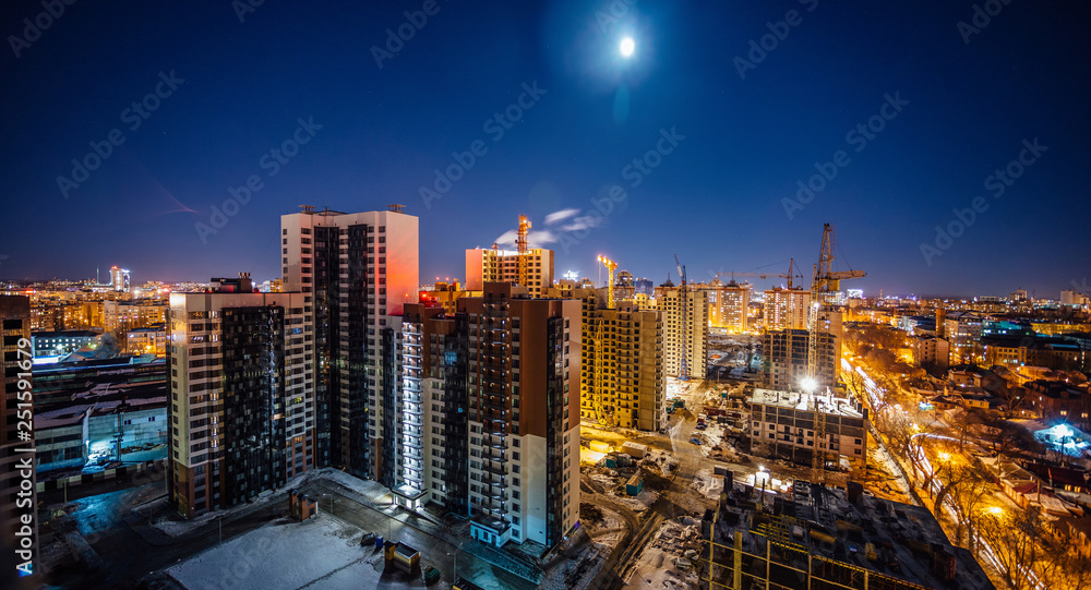 Construction of modern high multistory residential buildings, night aerial view of building yard