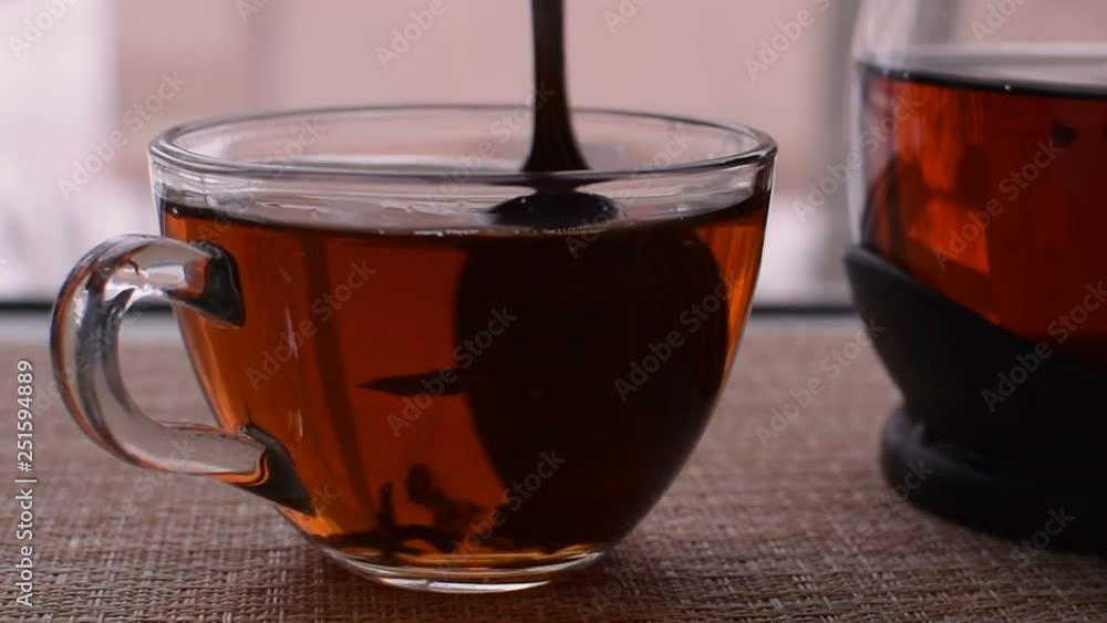 Transparent mug of tea. Spoon stir the tea. Traditional tea party. Transparent mug of tea. Spoon stir the tea. Traditional tea party.