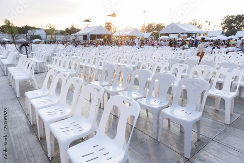 White plastic chairs in rows celebration and outdoor event with light flare.