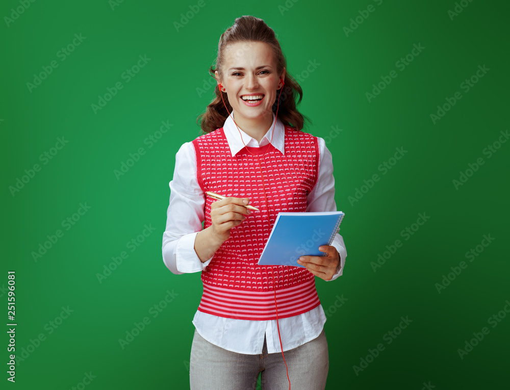learner woman in headphones taking notes in blue notebook learner woman in headphones taking notes in blue notebook