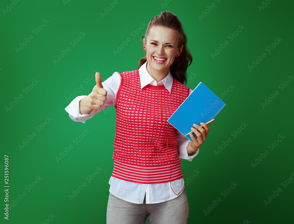 student in headphones with a blue notebook and golden pen showin student in headphones with a blue notebook and golden pen showin