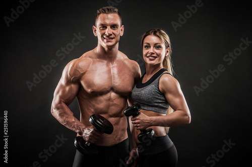 Sporty young couple posing on black background