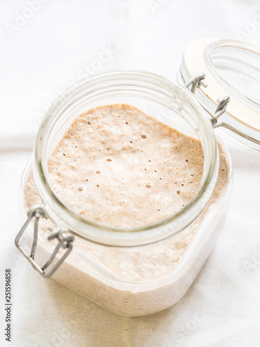 Rye sourdough starter in a jar on a clear background.