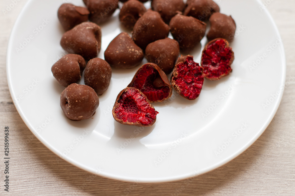 raspberry in chocolate on a white plate raspberry in chocolate on a white plate