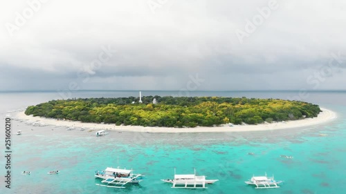 Aerial footage of Balicasag Island in Philippines. Stunning view on coral reef and circle island. Panglao, Bohol, white beach, palm trees, boats / 4K Drone Video